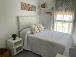 马拉加piso recinto ferial en teatinos的白色的卧室设有床和窗户
