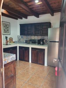 危地马拉安地瓜2 Pilas: historic colonial house的厨房配有木制橱柜和不锈钢冰箱。