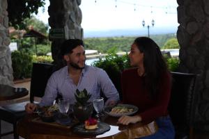 下博克特Hacienda Los Molinos Boutique Hotel & Villas的坐在餐桌旁吃饭的男人和女人