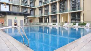 阿布扎比Chalet 2BR Duplex Apartment的一座带椅子的大型游泳池