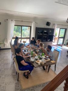 塞辛布拉Casa Calidris - Bed, Wine & Breakfast的一群坐在餐桌旁吃饭的人