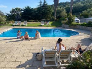 塞辛布拉Casa Calidris - Bed, Wine & Breakfast的一群人坐在游泳池周围