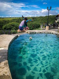 下博克特Hacienda Los Molinos Boutique Hotel & Villas的在游泳池玩足球的人