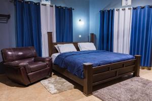 阿克拉BlueGreen GuestHouse的一间卧室配有一张床和一张皮椅