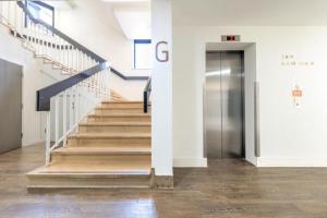 贝德福德Van Gogh Apartment, Bedford - Fast Wifi, Gym & FREE Parking的大楼内带楼梯和电梯的走廊