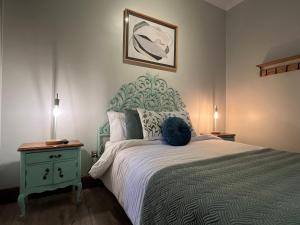 圣地亚哥Hotel Casa Aure的一间卧室配有一张大床和蓝色床头板