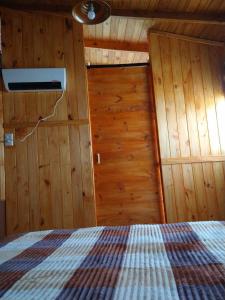埃博森Raíces del Bolsón的木制客房内的一间卧室,配有一张床