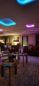 阿古拉耶特منتجع سمايل的客厅配有沙发、桌子和蓝光灯。