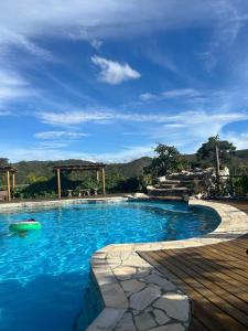 西波山Pousada Serra Morena的蓝色海水游泳池和木甲板