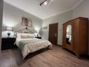 圣地亚哥Hotel Casa Aure的一间卧室配有一张床、梳妆台和镜子