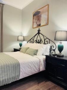 圣地亚哥Hotel Casa Aure的一间卧室配有一张床、两盏灯和一张照片