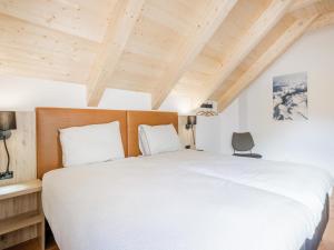 多内尔斯巴赫瓦尔德Auerhahn的卧室设有白色的床和木制天花板。