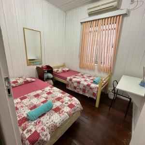 伊瓜苏Casa do Sussego的客房设有两张床、一张桌子和镜子