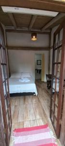乌巴图巴Prumirim Surf Suítes的卧室配有白色的床,铺有木地板