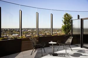 查斯顿Hotel Chadstone Melbourne, MGallery的从带椅子和桌子的建筑顶层欣赏美景