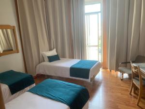 里斯本罗西公寓的酒店客房设有两张床和窗户。