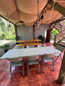 GandocaShiosai Retreat Cabins的天井上配有一张白色的大桌子和椅子