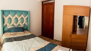 库斯科Departamento Familiar Equipado的一间卧室配有一张蓝色床头板的床