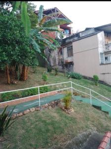 里约热内卢Casa Grande e Confortável的一座花园,旁边是一座建筑,设有围栏