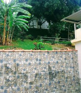 里约热内卢Casa Grande e Confortável的房屋前的石墙