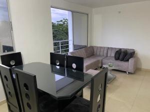 库库塔Habitación en Apartamento amplio cómodo y equipado的客厅配有玻璃桌和沙发