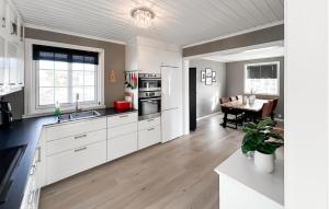 SpangereidGorgeous Home In Lindesnes With Kitchen的厨房配有白色橱柜和桌子