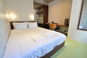 静冈阿本特静冈酒店的一间卧室配有一张大床和两条毛巾
