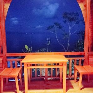 布纳肯Bunaken 18 Diving Resort and Cafe的窗前的一张桌子和两把椅子