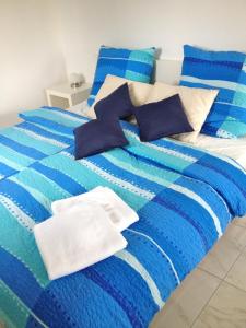 PatzigFerienwohnung in Patzig auf Rügen的蓝色和白色的床,配有蓝色和白色的床单和枕头