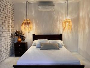 圣玛尔塔Casa campestre con piscina cerca al aeropuerto y la playa的一间卧室配有白色床和两盏灯