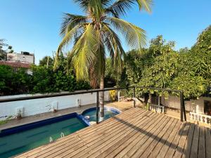圣玛尔塔Casa campestre con piscina cerca al aeropuerto y la playa的棕榈树甲板和游泳池