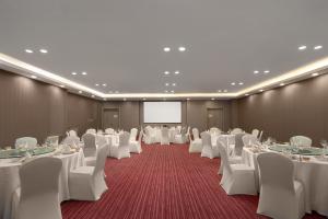 抚松县长白山万达Momoland酒店的一间会议室,配有白色的桌椅和屏幕