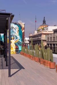 墨西哥城Suite 2 camas y sofa cama的一座有女人和仙人掌壁画的建筑