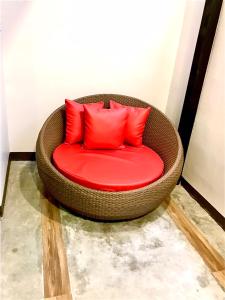 曼谷V20 Boutique Jacuzzi Hotel - SHA Extra Plus的客房内的藤椅和红色枕头