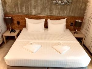 曼谷V20 Boutique Jacuzzi Hotel - SHA Extra Plus的一间卧室配有带白色床单和枕头的床。