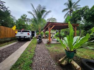 曼巴豪CamiStays Homestay in Camiguin, Best for Groups or Family的停在摩托车旁亭下的卡车