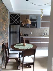 南卡希亚斯Apartamento na Serra Gaúcha的厨房配有桌椅和冰箱。