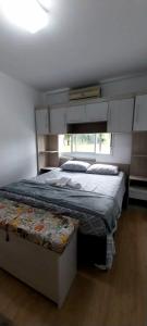 南卡希亚斯Apartamento na Serra Gaúcha的一间卧室设有一张大床和一个窗户。