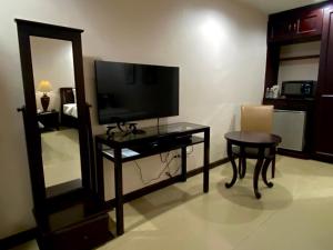 巴科洛德卡尔努瓦套房酒店的客厅配有电视、桌子和镜子