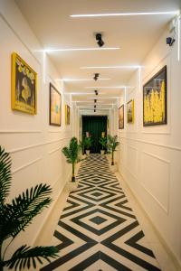 法里达巴德Agrah Stay - Kasa Lusso Stay的墙上挂有植物和画作的走廊
