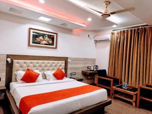 达兰萨拉King Castle fully ac hotel Near Mall Road的一间卧室配有一张带橙色枕头的床和一张书桌
