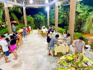 潘切Me Bungalow Beach Resort的一群人在餐厅餐桌上吃饭