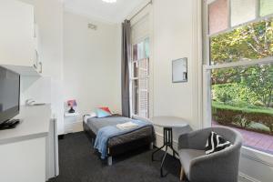 悉尼Falcon Lodge的客房设有床、椅子和窗户。