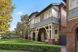 悉尼Falcon Lodge的一座古老的砖房,前面有一个花园