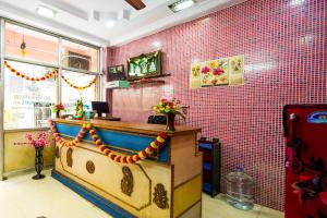 蒂鲁帕蒂SPOT ON Venkata Sai Residency的餐厅内的酒吧拥有粉红色的瓷砖墙壁