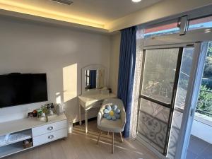 Dongyin/北澳秘山居 的客厅配有电视、书桌和椅子