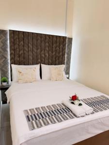 刁曼岛菲特亚咖啡木屋的一间卧室配有一张白色大床,床上有鲜花