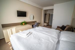 奥洛穆茨杜姆旅馆的卧室配有白色的床和沙发