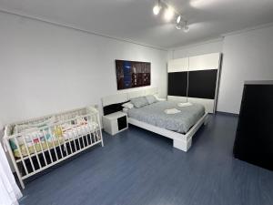 萨龙El pisuco的一间卧室配有两张床和一张婴儿床。