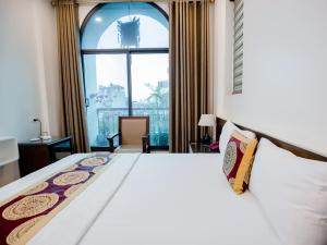 河内Phuong Nam Luxury Hotel Long Bien的一间卧室设有一张大床和大窗户